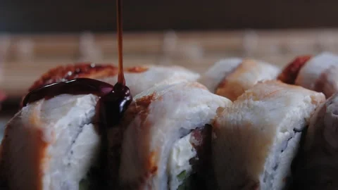 Cooked sushi rolls with eel adding thick sauce unagi to the rolls before serving Stock Footage 149094059