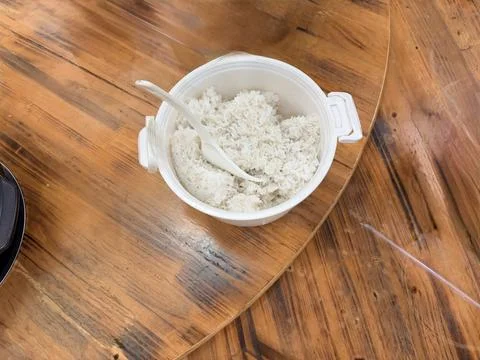 Cooked White Rice in Plastic Container on Wooden Table Stock Photos