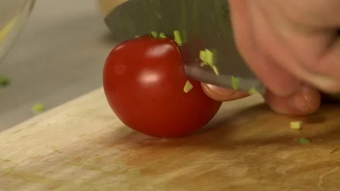 Cooker cutting off tomato pulp on cookery board Stock Footage 71388860