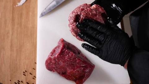 Cooker Man form beef meat cutlet for black ham burger top view Stock Footage 94034745