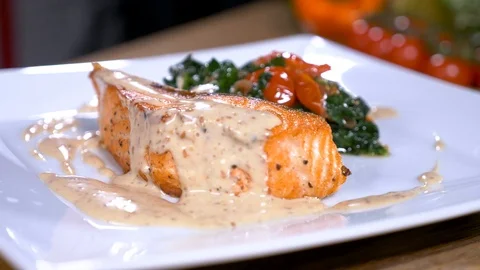 Cooker put a basil leaf to a salmon and spinach meal in cafe. Stock Footage 94264348