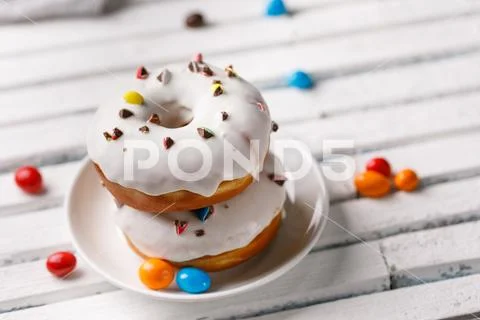 Cookery, baking and food concept - closeup. Two donuts lying on top of each o Stock Photos