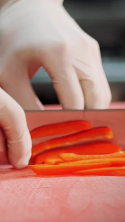 Cookery. chef, in protective gloves, slicing red bell pepper, cutting pepper Stock Footage 320301017