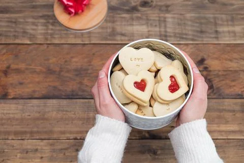 Cookie box in the shape of a heart and women's hands. Concept Valentine's Day Stock Photos