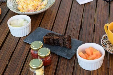 Cookie cake next to a portion of papaya, melon and assorted jellies. Stock Photos