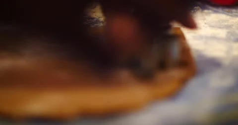 Cookie cutters being used on gingerbread cookie dough to make cookies close up Stock Footage 217358526