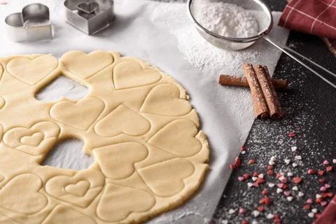Cookie dough with metal forms in the shape of heart, cinnamon sticks, powdere Foto stock