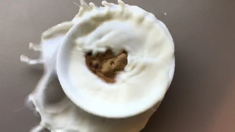 Cookie Falling Into A Bowl Of Milk Stock Footage 120883679