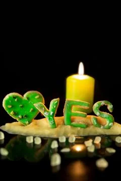 Cookie letters, cookie dough, a candle and icing sugar, wort yes  in front of 스톡 사진