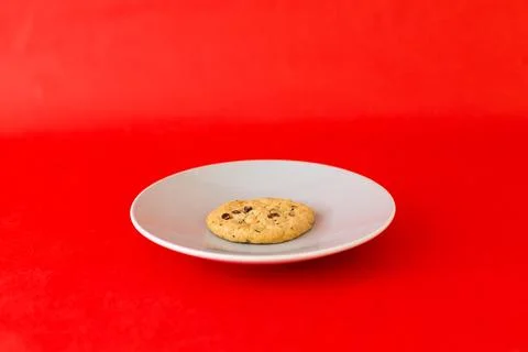 A cookie is on a plate on a red background Stock Photos