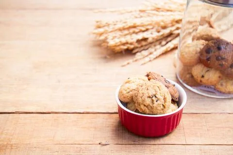 Cookie in red cup on wood table with copy space. vintage tone. Selective focu Stock Photos