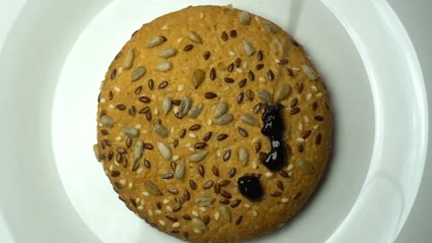 Cookie rotating on white plate and pouring chocolate. Top view Stock Footage 85992879