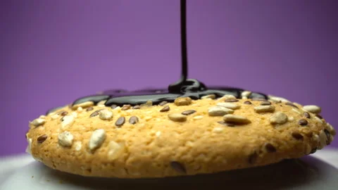 Cookie rotating on white plate and pouring chocolate. Side view Stock Footage 85993032