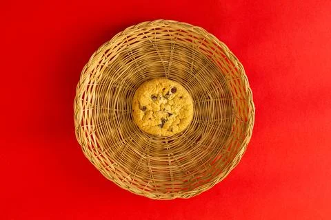 A cookie is sitting in a basket on a red background Stock Photos