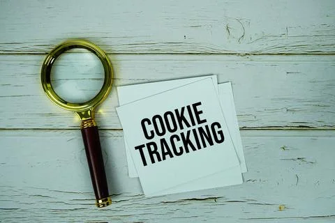 Cookie Tracking text message on paper with magnifying glass on wooden backg.. Stock Photos