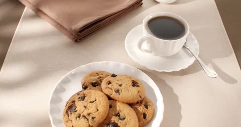 Cookies and a cup of coffee on a beige and brown background. Slow camera slide Stock Footage 242590122