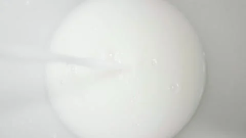 Cookies and milk pouring into a bowl while rotating Stock Footage