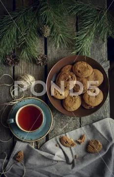 Cookies and tea on wooden table with pine cones Stock Photos