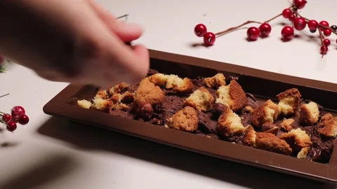 Cookies are spread over melted chocolate in a silicone mold. Stock Footage 293216113