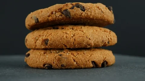 Cookies with chocolate on a black rotating table. 動画素材 103986532