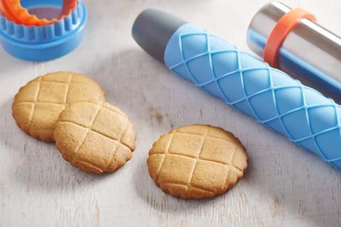 Cookies, embossing rolling pin with checkered pattern and cookie cutters Fotos de archivo