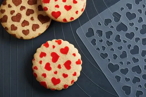 Cookies with a pattern in the form of red hearts, stencil on a baking mat Stock Photos