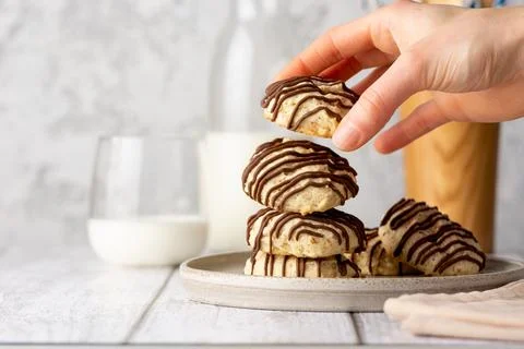 Cookies in a woman's hand. Stack of nut crunchy cookies covered with chocolate Stock Photos