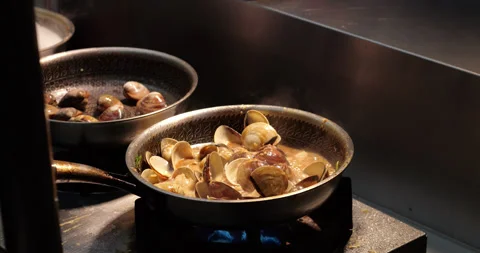 Cooking and boiling fresh clams in savory sauce at night market Vídeo Stock 341099411