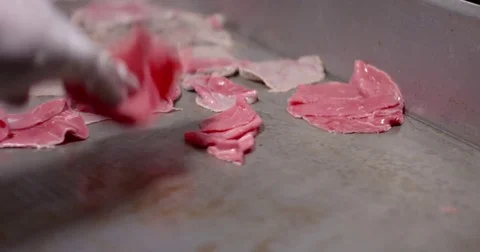 Cooking and chopping an authentic Philly Cheesesteak on a restaurant griddle Stock Footage 85036966