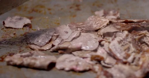 Cooking and chopping an authentic Philly Cheesesteak on a restaurant griddle Stock Footage 85039117