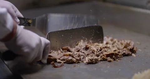 Cooking and chopping an authentic Philly Cheesesteak on a restaurant griddle Vídeos de archivo 85040719