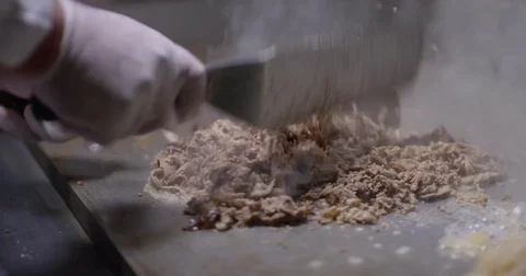 Cooking and chopping an authentic Philly Cheesesteak on a restaurant griddle Stock Footage 85041704