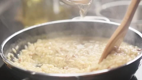 Cooking and stirring risotto with mushroom in the frying pan. Stock Footage 154370568