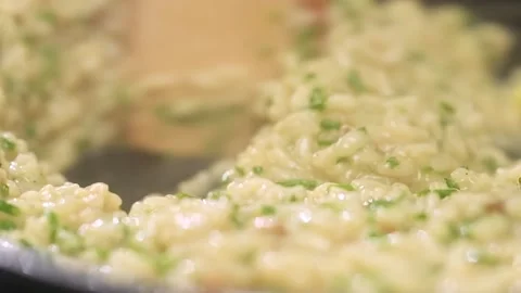 Cooking and stirring risotto with mushroom in the frying pan, slow motion. Stock Footage 154370613