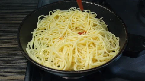 Cooking and stirring the spaghetti with vegetable in the frying pan Stock Footage 196430123