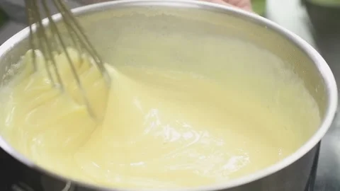 Cooking and stirring of vanilla pudding in a saucepan. Stock Footage 151693340