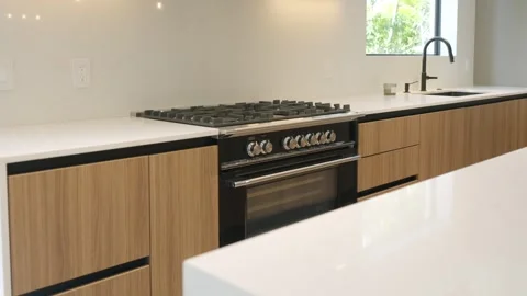 Cooking area in kitchen with white marble island for extra counter space Stock Footage 280494125