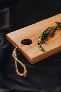 Cooking background concept. Close view of wooden cutting board with rosemary on Stockfoto's