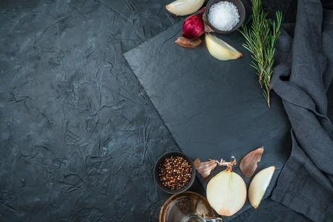 Cooking background with copy space, flat plate, onion and spices on black Foto stock