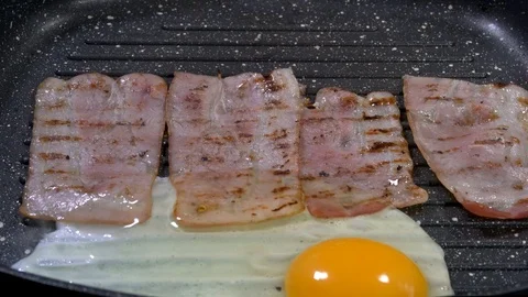 Cooking bacon and eggs on a grill pan Stock-Footage 88260850