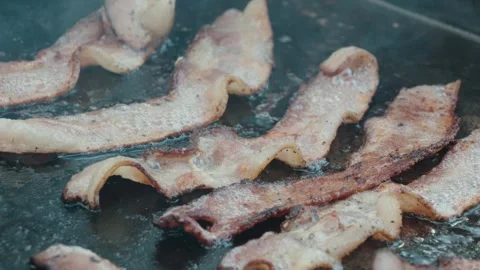 Cooking bacon outside on a griddle Video stock 284777265