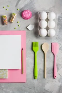 Cooking baking flat lay background notebook cupcake molds eggs tools Stock Photos