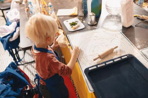 Cooking baking workshop class for school kids. Cute little boy in kitchen Stock Photos