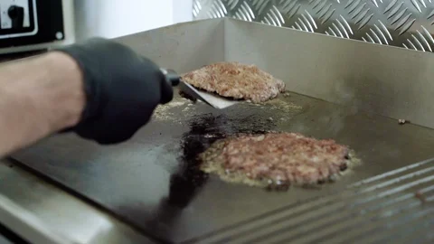 Cooking beef and pork cutlets for a burger. Chef removing cutlets from the pan Stock Footage 115841790