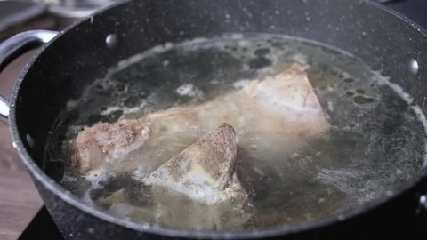 Cooking beef in black pot on induction board in the kitchen. Stock Footage 148420841