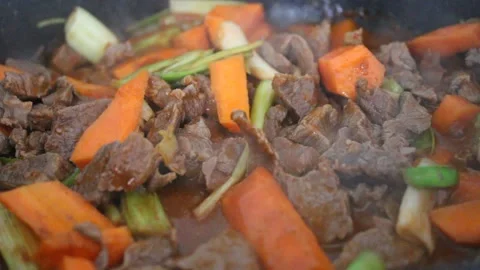 Cooking beef meat and vegetables , beef stew with carrot and leek, close up view Stock Footage 174081403