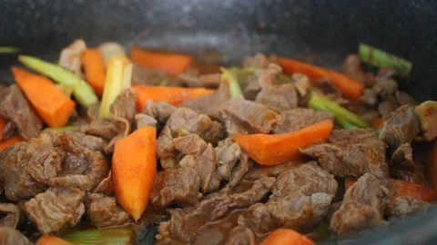 Cooking beef meat and vegetables , beef stew with carrot and leek, close up view Stock Footage 180449718