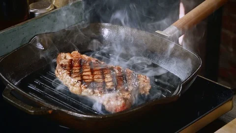 Cooking beef steak. One beef fillet meat is being fried in a grill pan. 4K Stock Footage 84256241