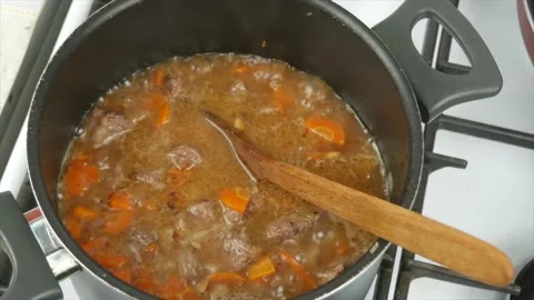 Cooking beef stew with vegetables at home, close-up, wooden spoon - healthy d Stock Footage 133714945