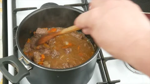 Cooking beef stew with vegetables at home, close-up, wooden spoon - healthy d 動画素材 133714964